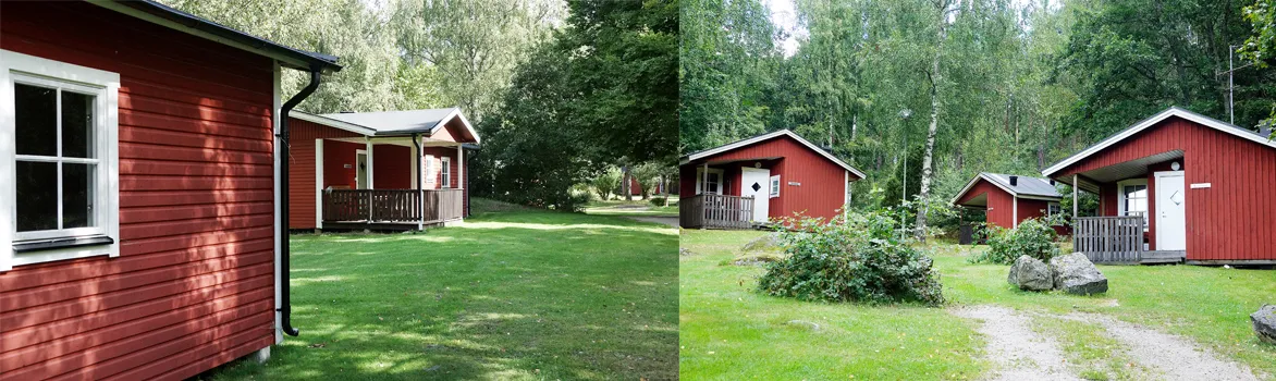 Röda stugor bland gräsmattor och lövträd i stugbyn