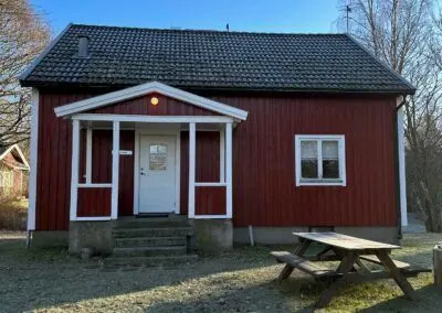 Torpet, ett rött hus i två våningar med vit veranda